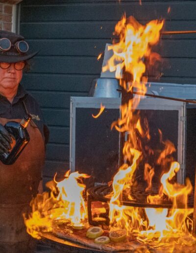Grill Master Joop van Uw Chef Catering flambeert vlees op de Ofyr op de Piet's 70 party. Foto: AbDonkerFotografie