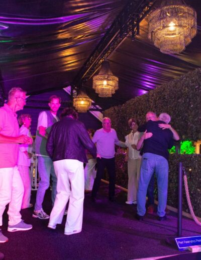 De gasten van op Piet's 70 party dansen onder feestelijke tent met kleurrijke verlichting van kroonluchters, heaters en decoratie. Foto: AbDonkerFotografie.